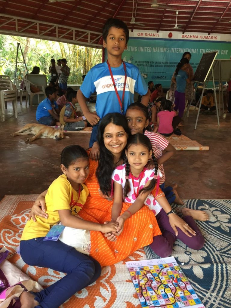 A mentor sitting warmly with a group of children